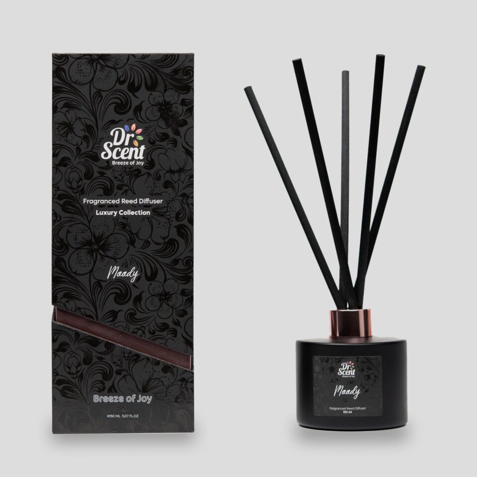 Moody reed diffuser in a black jar with black reeds beside its black gift box
